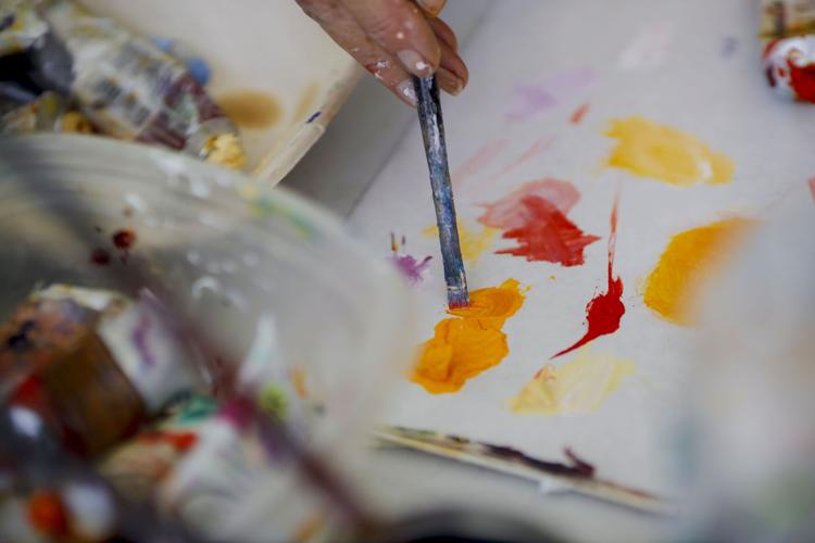 paint brush dipping into orange