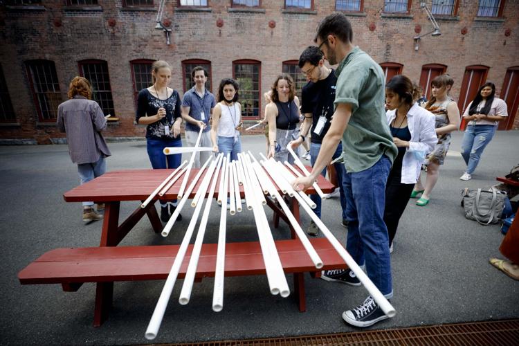 crowd of people grab a pvc pipe from a table