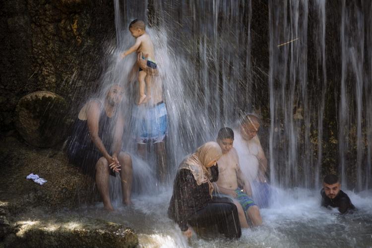 People stand under a waterfall