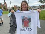 Judy Coty holds a T-shirt with an image of her son, Aaron