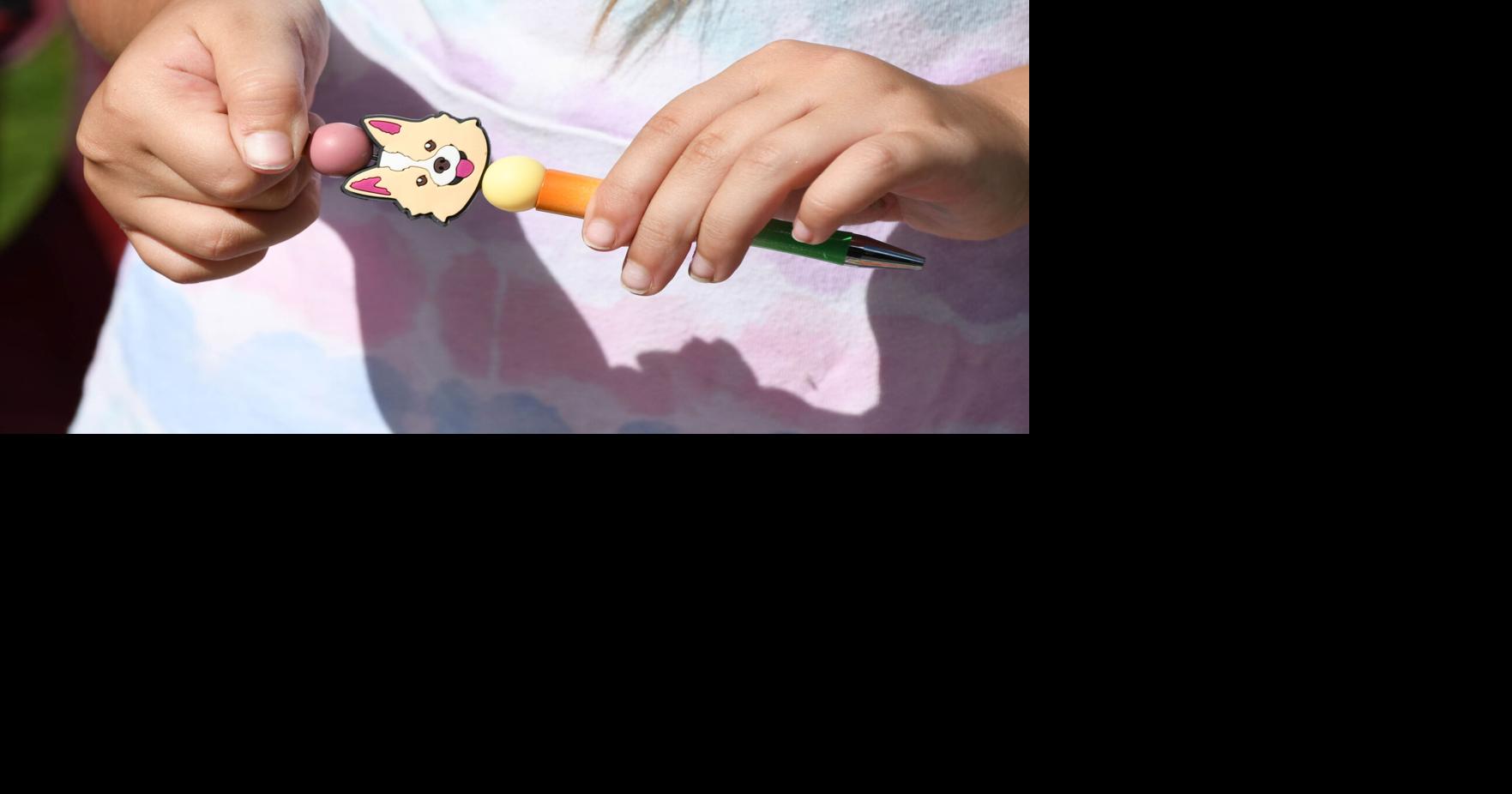 A girls creates a decorated pen for writing