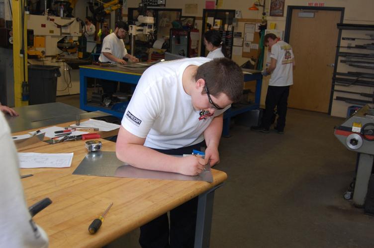 A student working with sheet metal