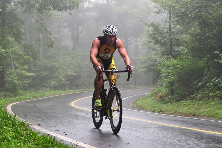 A man cycles through the heavy fog on Mount Greylock