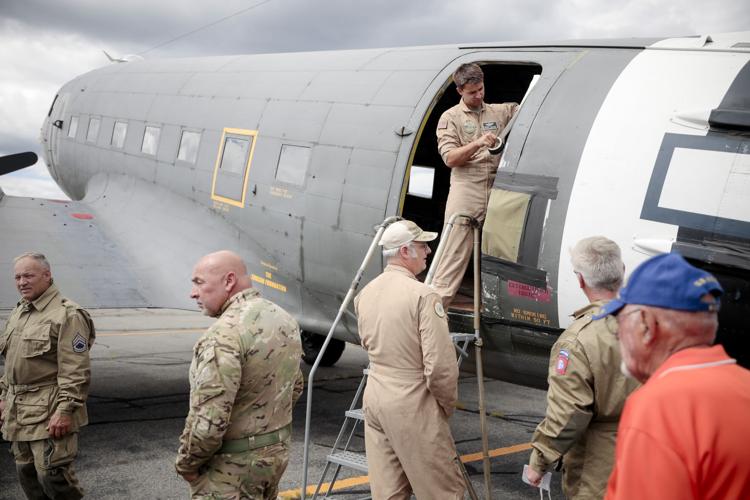 pilot in flight suit tapes doorway of vintage cargo plane