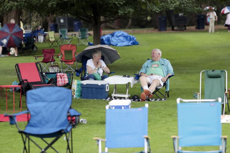 couple laughs in lawn chairs surrounded by empty lawn chairs
