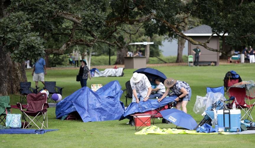 people on grass cover chairs and picnics with blue tarps