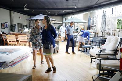 Shoppers walk through furniture showroom looking at patio furniture