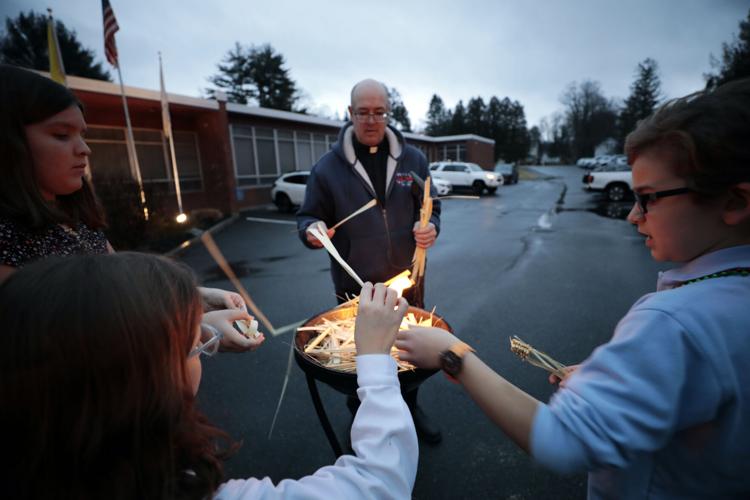 Brian McGrath and children place dried palms into fire