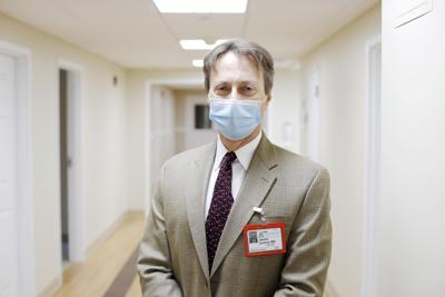 Dr. James Lederer in a mask and a tan suit jacket