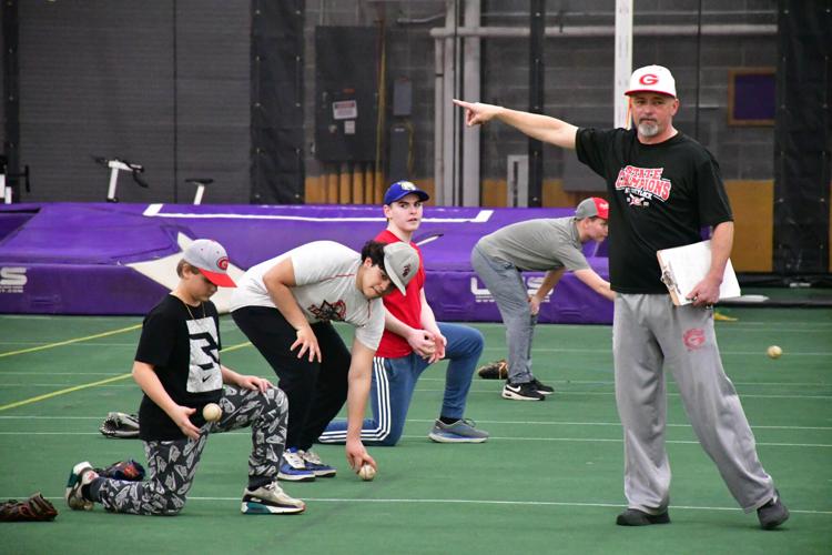 A coach works with his baseball players