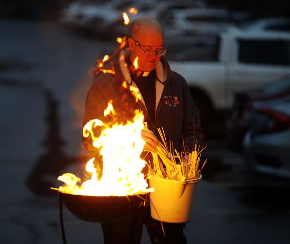 Brian McGrath placing palms onto fire