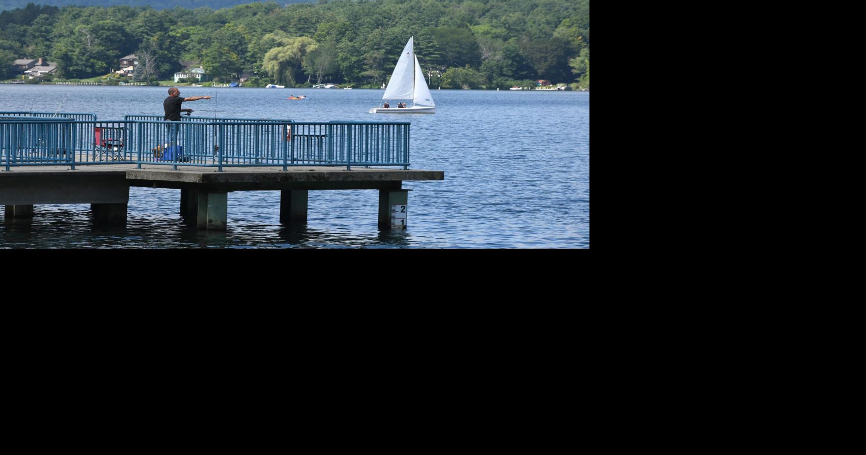 People fish and sail on a lake