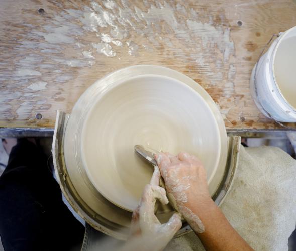 hands make bowl on pottery wheel