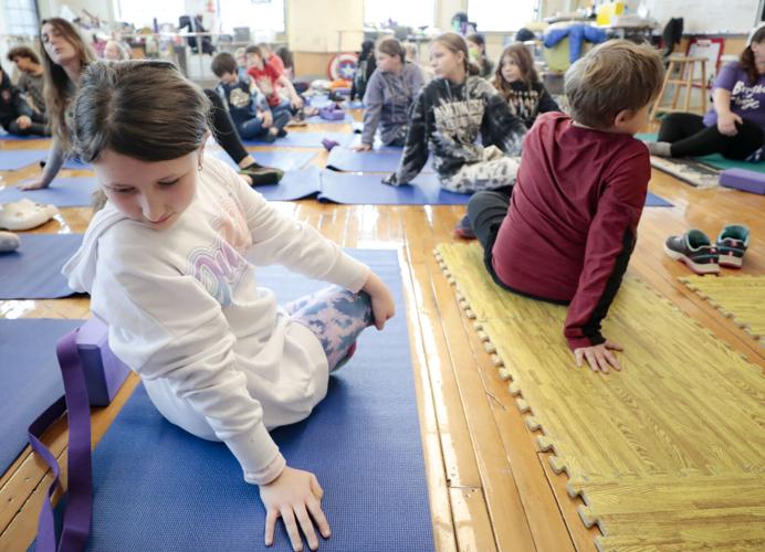 kids stretch on yoga mats in class