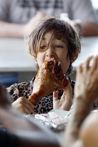 boy takes big bite of large turkey leg