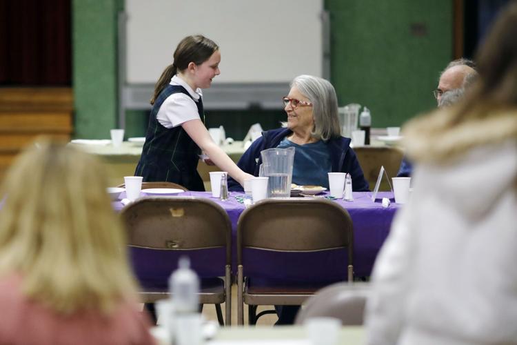 Zooey Bayles handing plate to woman at table