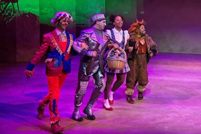 Four actors skipping up stage in Wizard of Oz