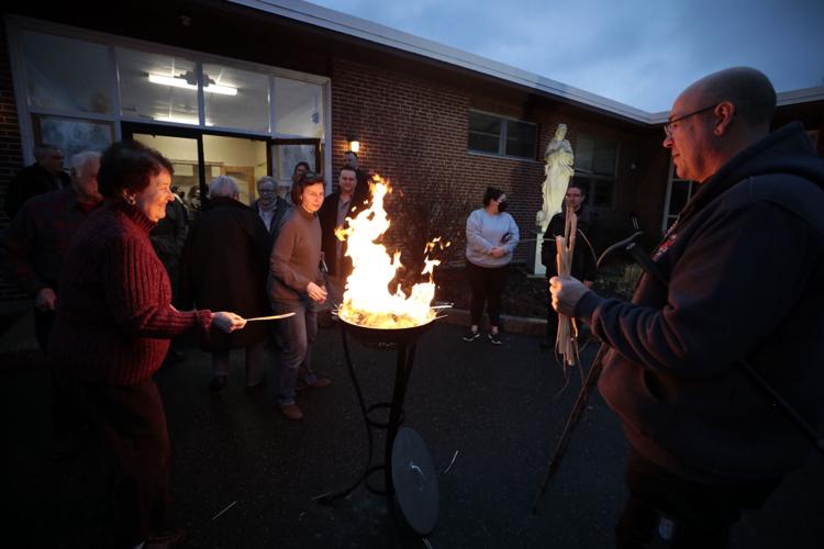 people placing dried palms into fire