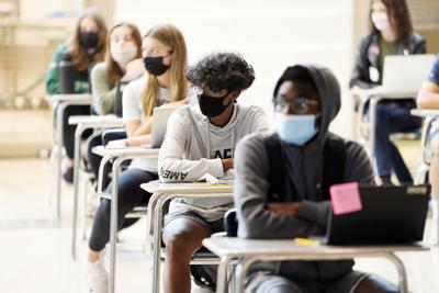 Students sitting at desks wearing masks