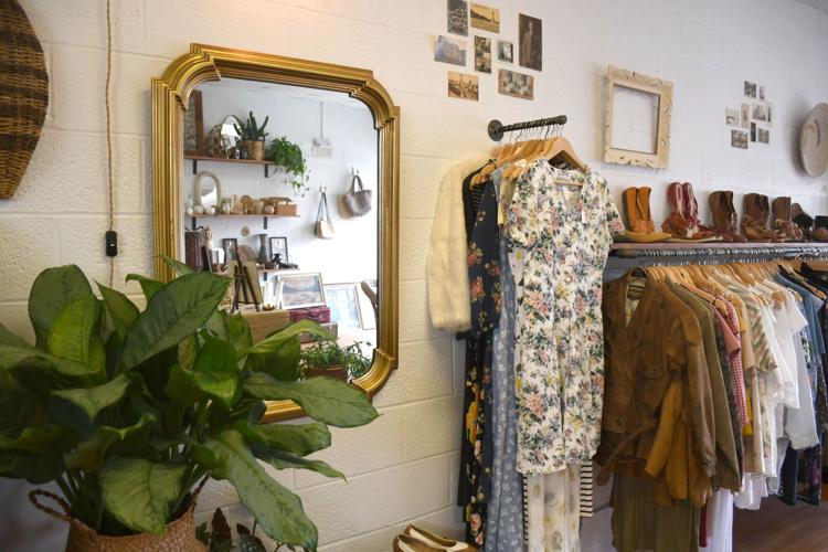 A mirror reflects items in the store as clothes and shoes are displayed at right