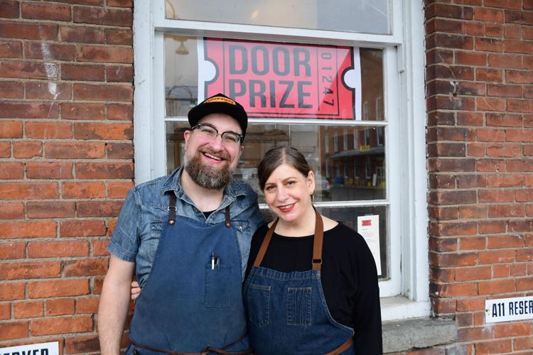 Josephs and Klowden stand in front of their restaurant sign