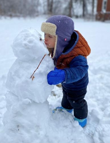 Boy kisses snowman