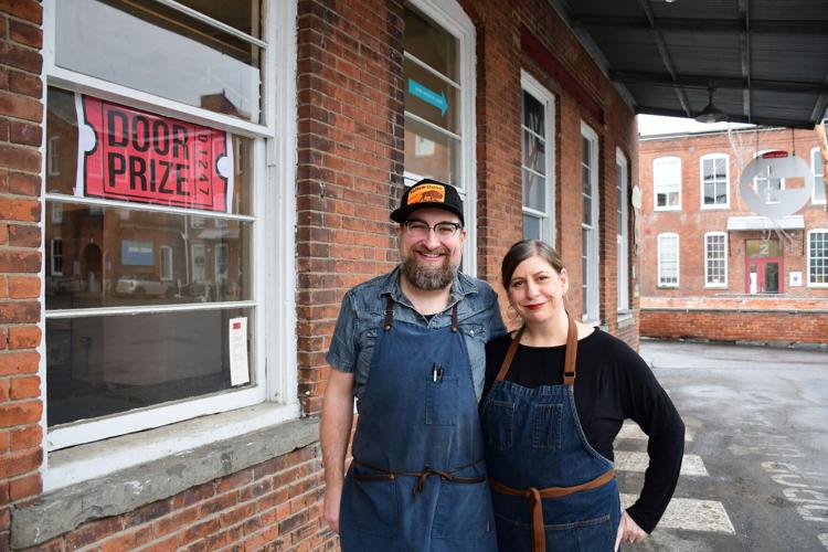 Josephs and Klowden stand in front of their restaurant sign