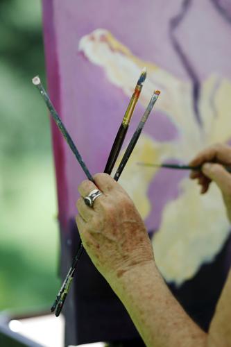 Diane Firtell holding three paint brushes