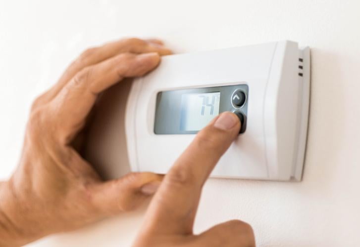 Hand touching thermostat