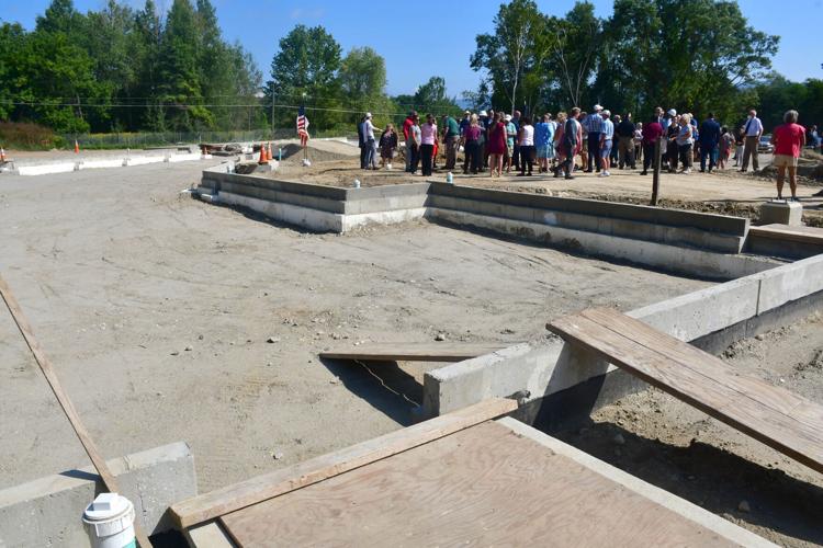 People stand near a foundation.