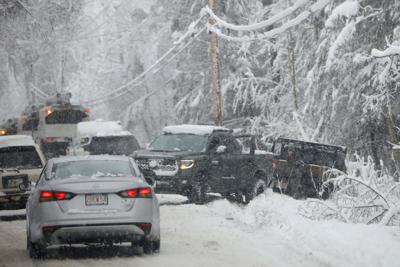 cars drive around pickup truck pulling truck out of snow