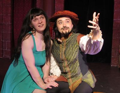 Two actors on stage, one gesturing to audience
