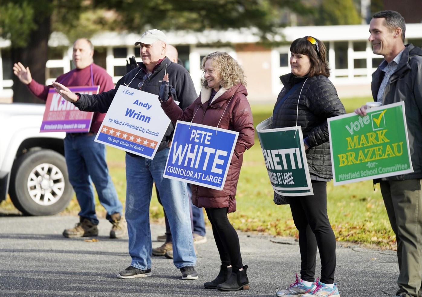 Supporters hold signs outside the polling place