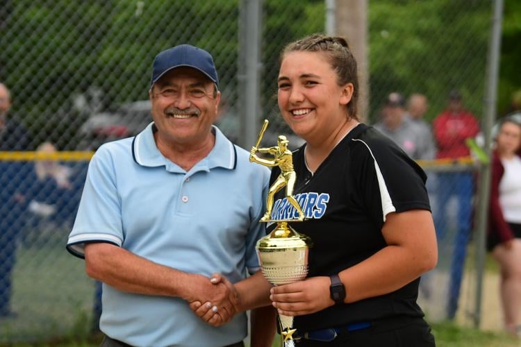 An umpire poses with a trophy and the winner of it