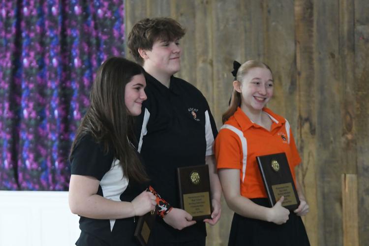 Teen girls pose with their plaques
