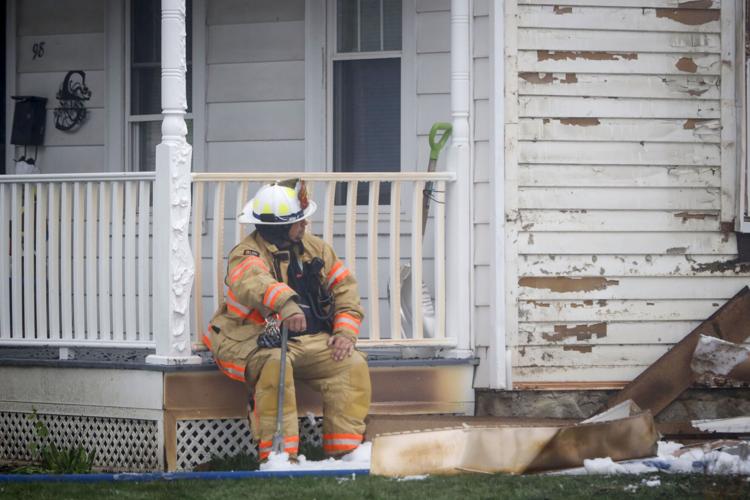 firefighter rests on porch after fire