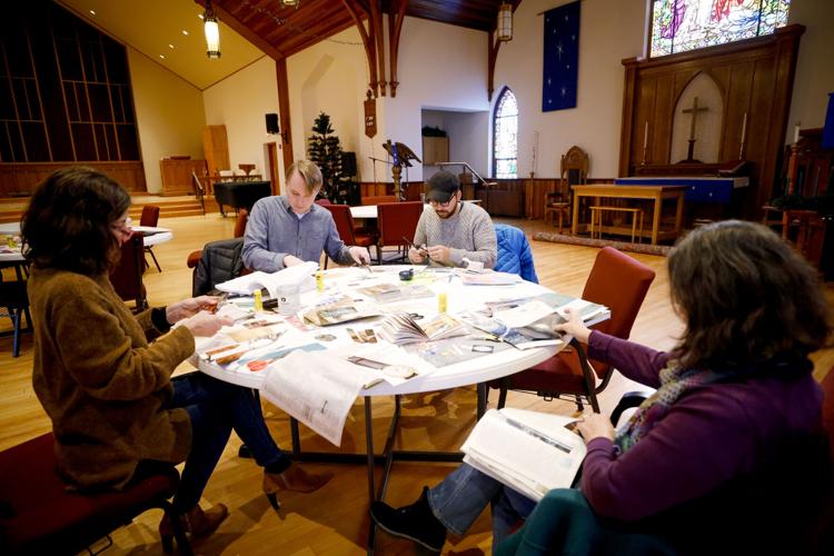 four people gather around craft table in church making collages