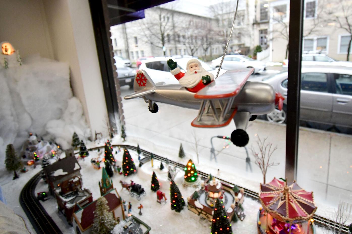 Santa Claus flies in a plane above the Christmas village