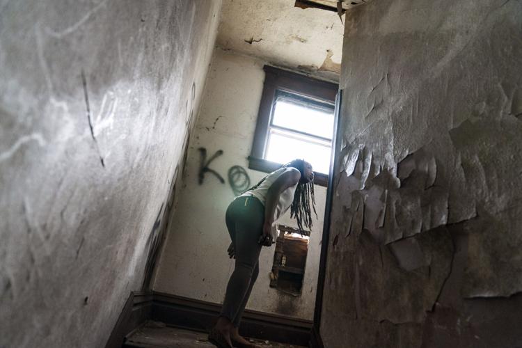 A woman peers around a stairwell