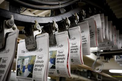 folded newspapers hanging from conveyor (copy)