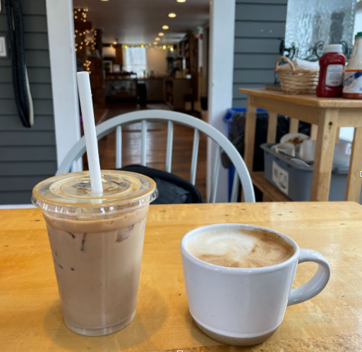 An iced coffee and a hot oat milk lattes on a table at Five Corners in Williamstown