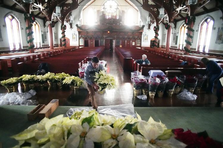 Brian Callahan places poinsettias around the altar at St. Charles Church in Pittsfield