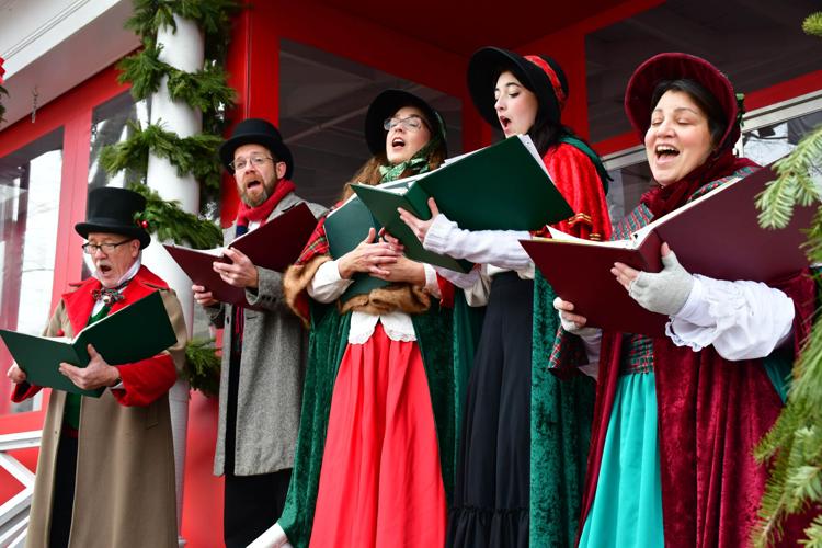 Carolers dressed in period clothing sing