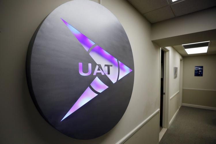 purple UAT sign with logo in office