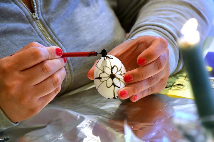 A woman decorates a egg