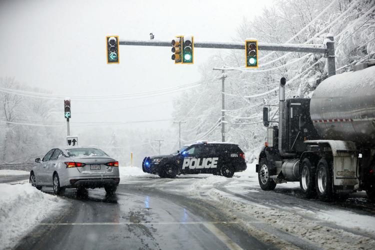 police car blocking traffic during snowstorm