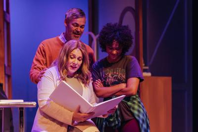 three people look at a book