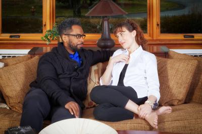Man and woman sit on brown couch