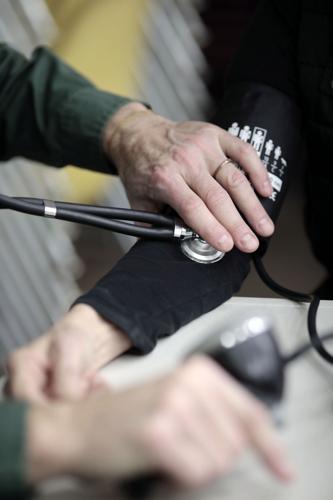 man uses blood pressure machine on woman's arm