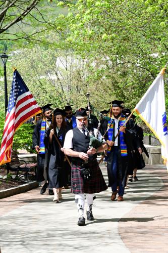 A bagpiper leads graduates to commencement